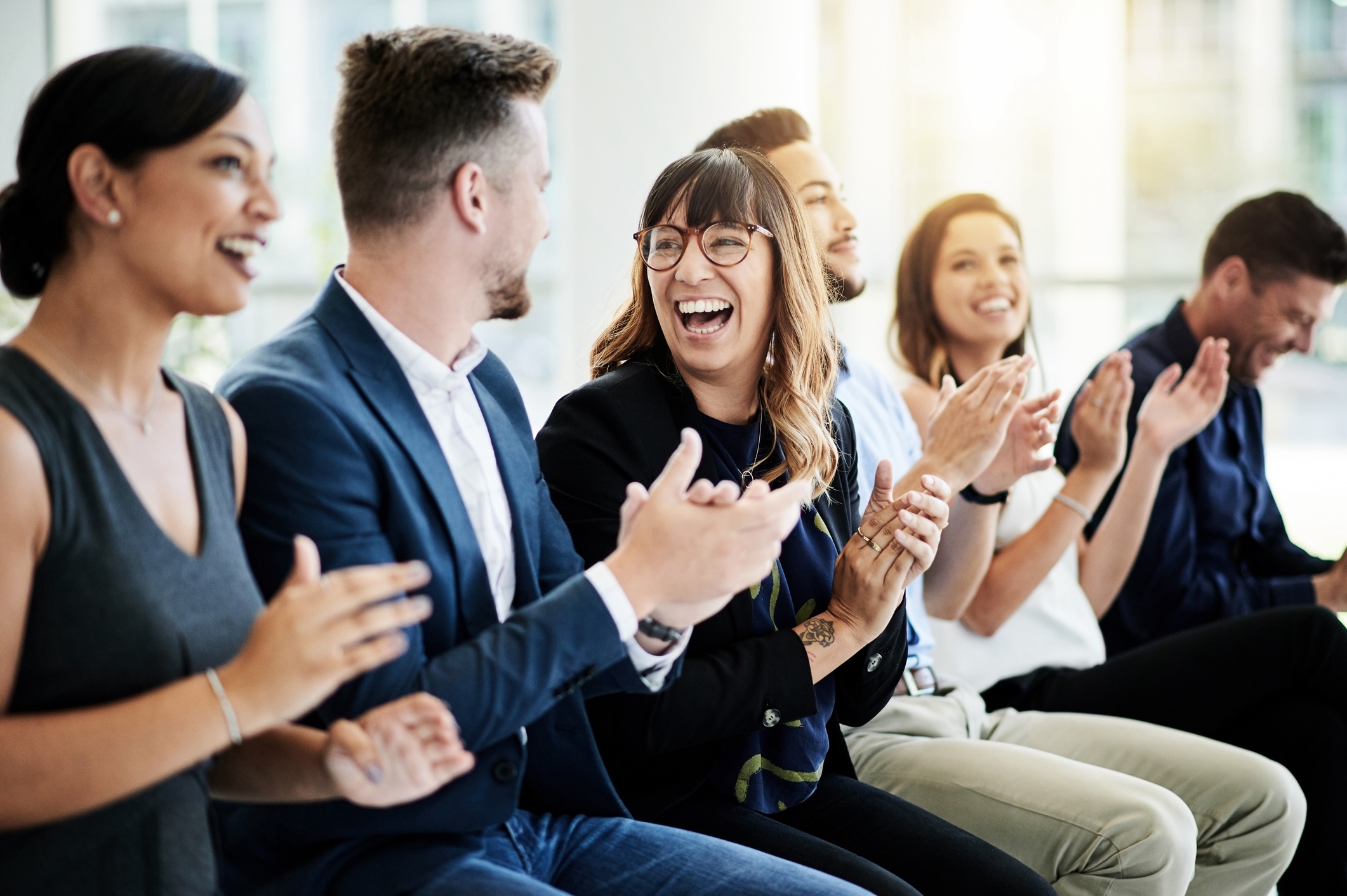 Business people sitting and clapping